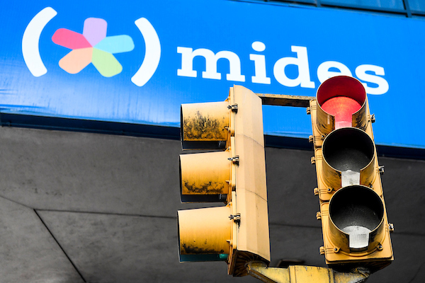 Un semáforo en rojo, se superpone al cartel de la fachada del MIDES