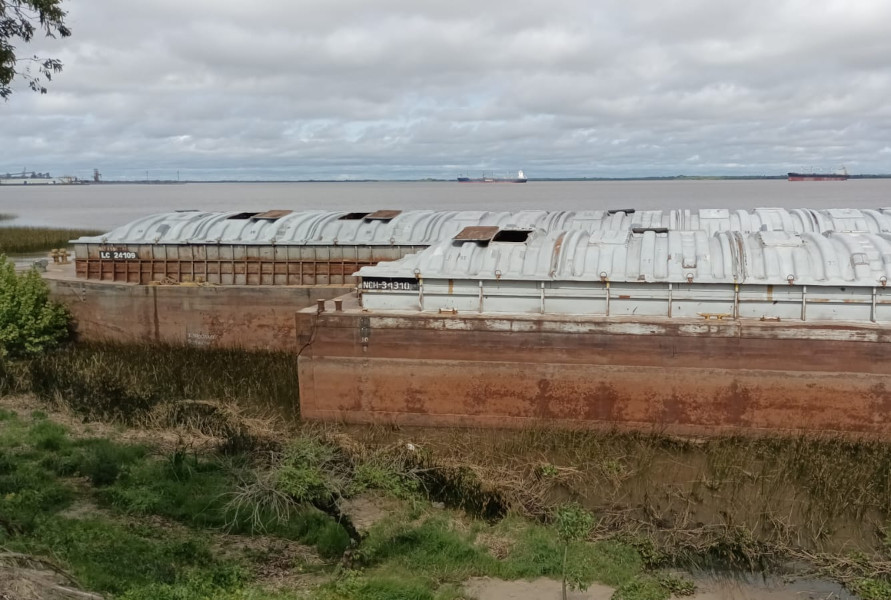 Dos de las cinco barcazas   sobre la costa de Brisas del Uruguay (Foto APU.uy)