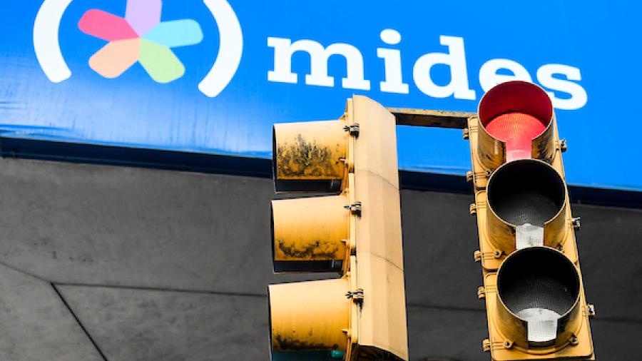 Un semáforo en rojo, se superpone al cartel de la fachada del MIDES