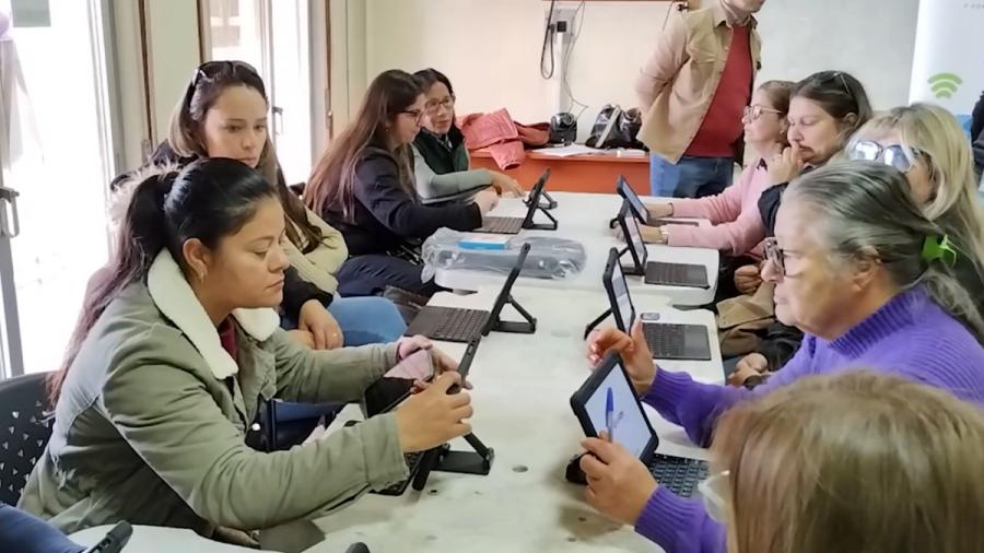 Mujeres aprendiendo el manejo de tabletas electrónicas.